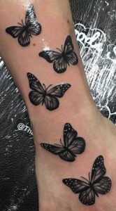 Black butterfly tattoo on hand