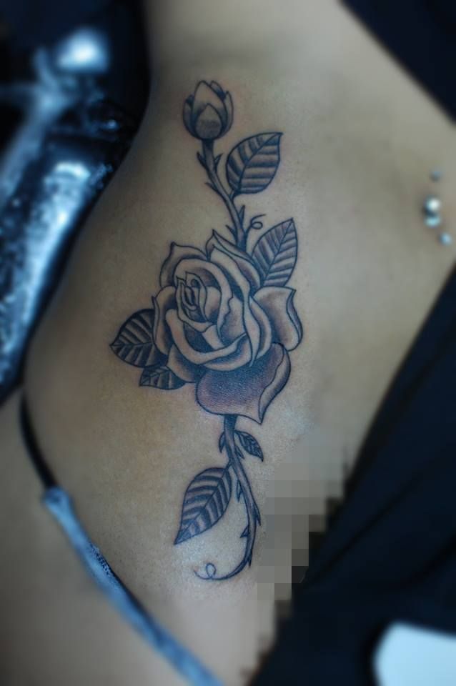 Black rose tattoo with an industrial piercing