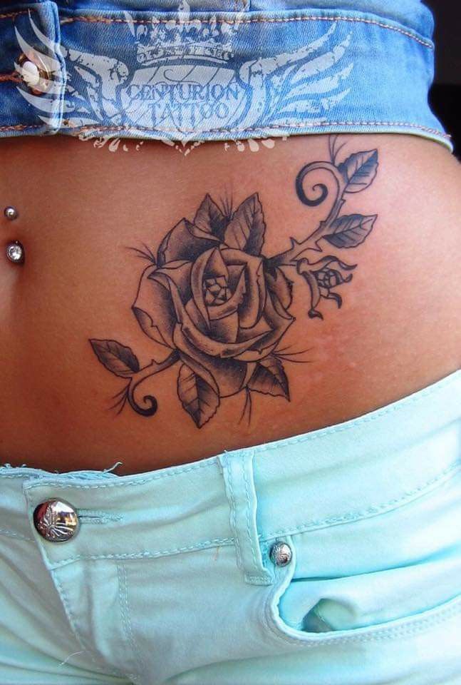 Rose tattoo around a belly ring