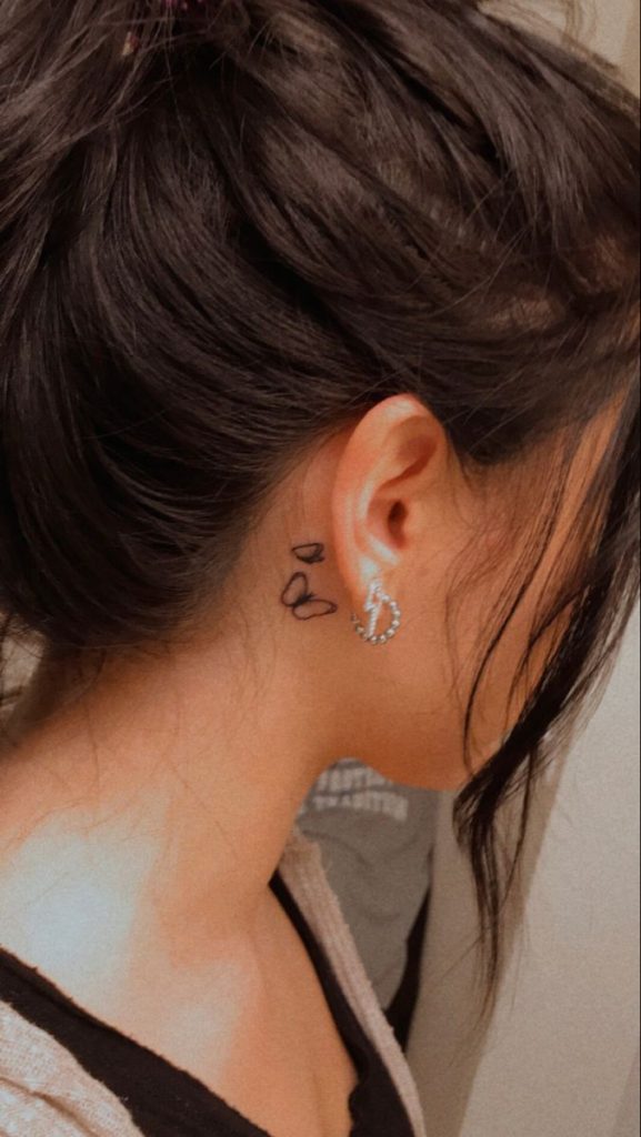 Thin line tattoo behind the ear with a single lobe piercing