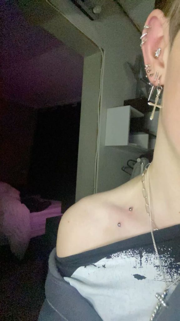 Tiny script above the collarbone with a dermal piercing
