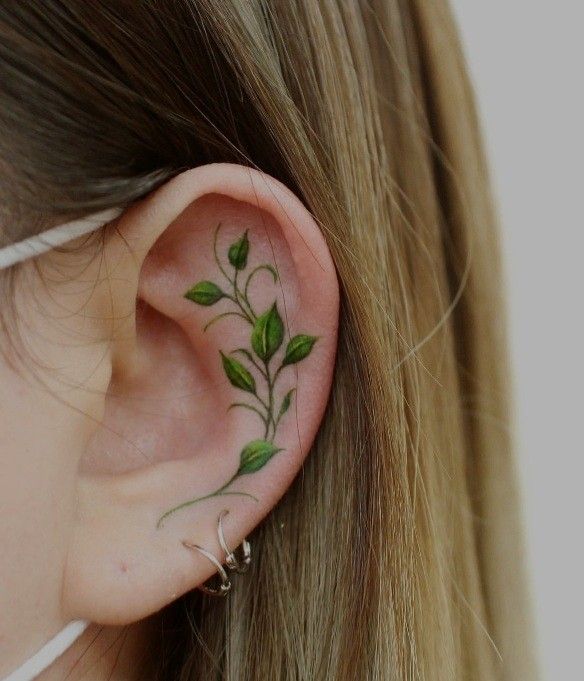 Vine tattoo near ear piercings